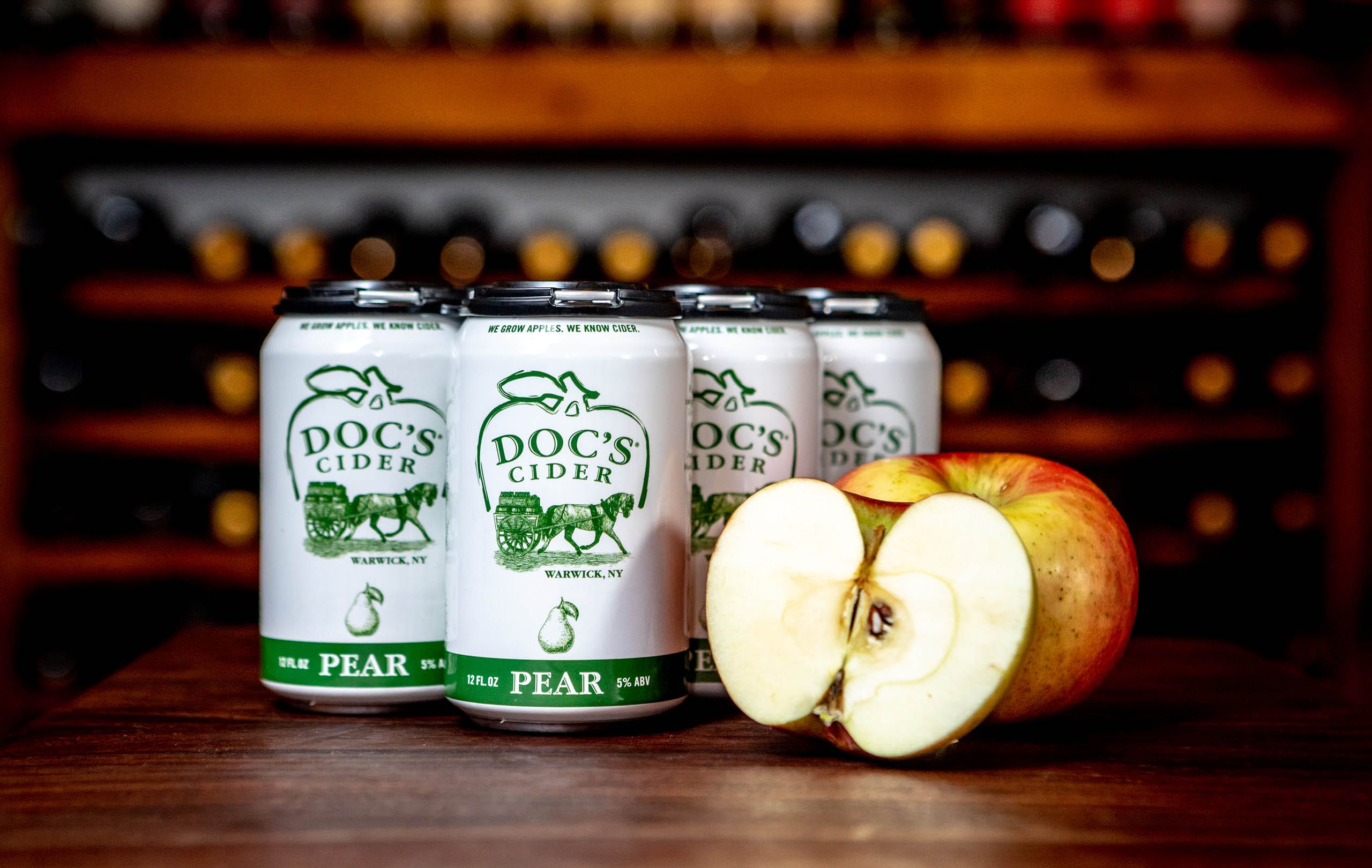 A can of Doc's Cider Pumpkin variety lying on a bed of autumn leaves, featuring vibrant red, orange, and yellow foliage.